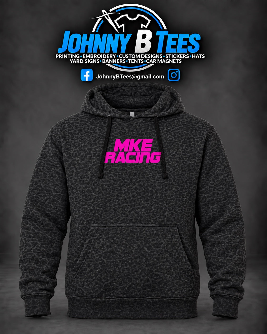 Black and charcoal leopard-print MKE Racing pullover hoodie with a hot pink chest logo, drawstring hood, and front pouch pocket.