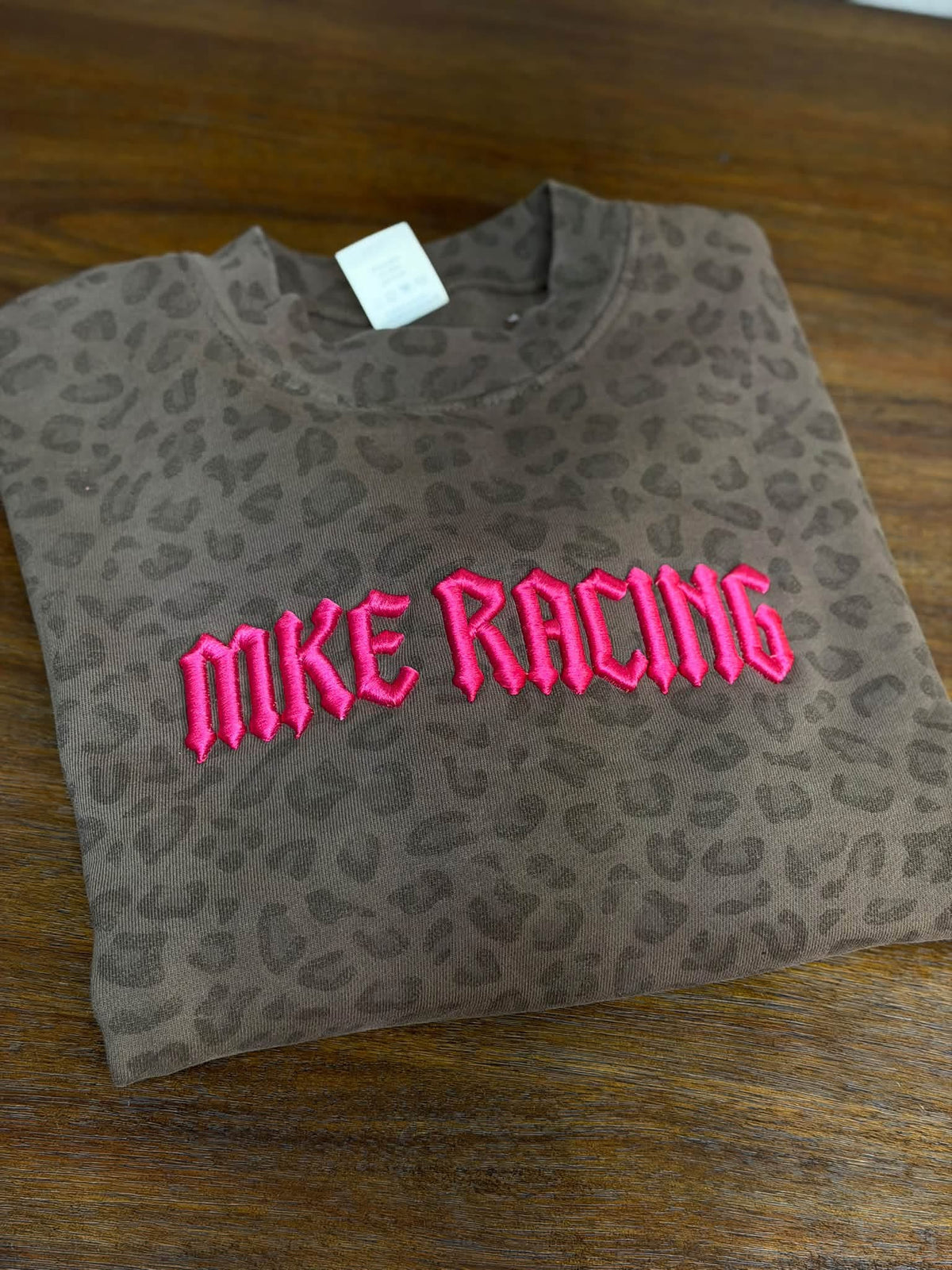 Leopard-print MKE Racing crewneck with raised hot pink puff embroidery across the chest.